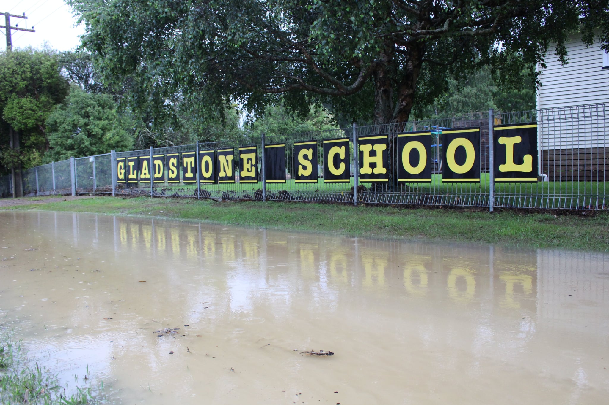 Flood water is pooled around the sign for Gladstone Primary School