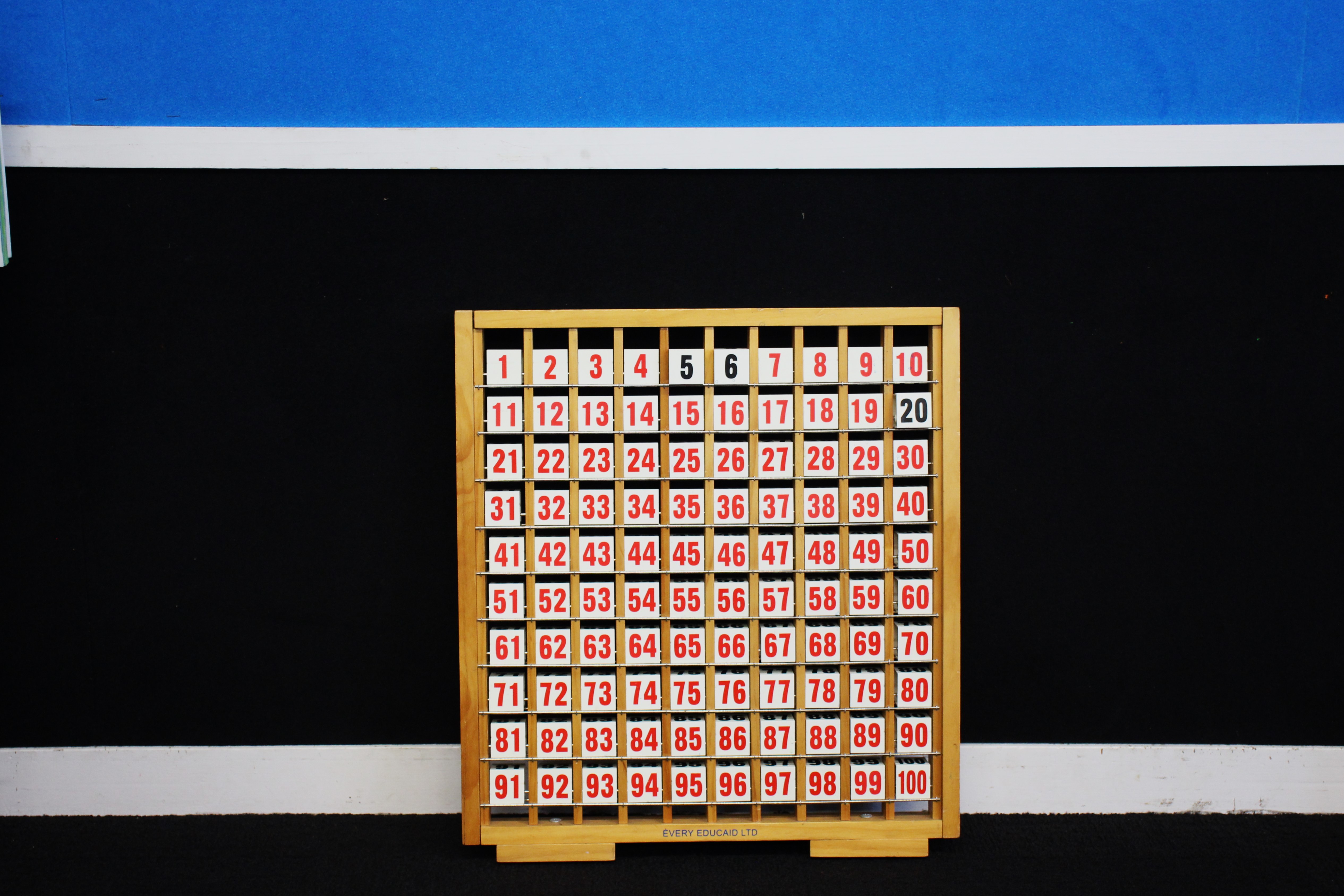 An interactive to with numbers 1-100 on it in front of a blackboard in a classroom