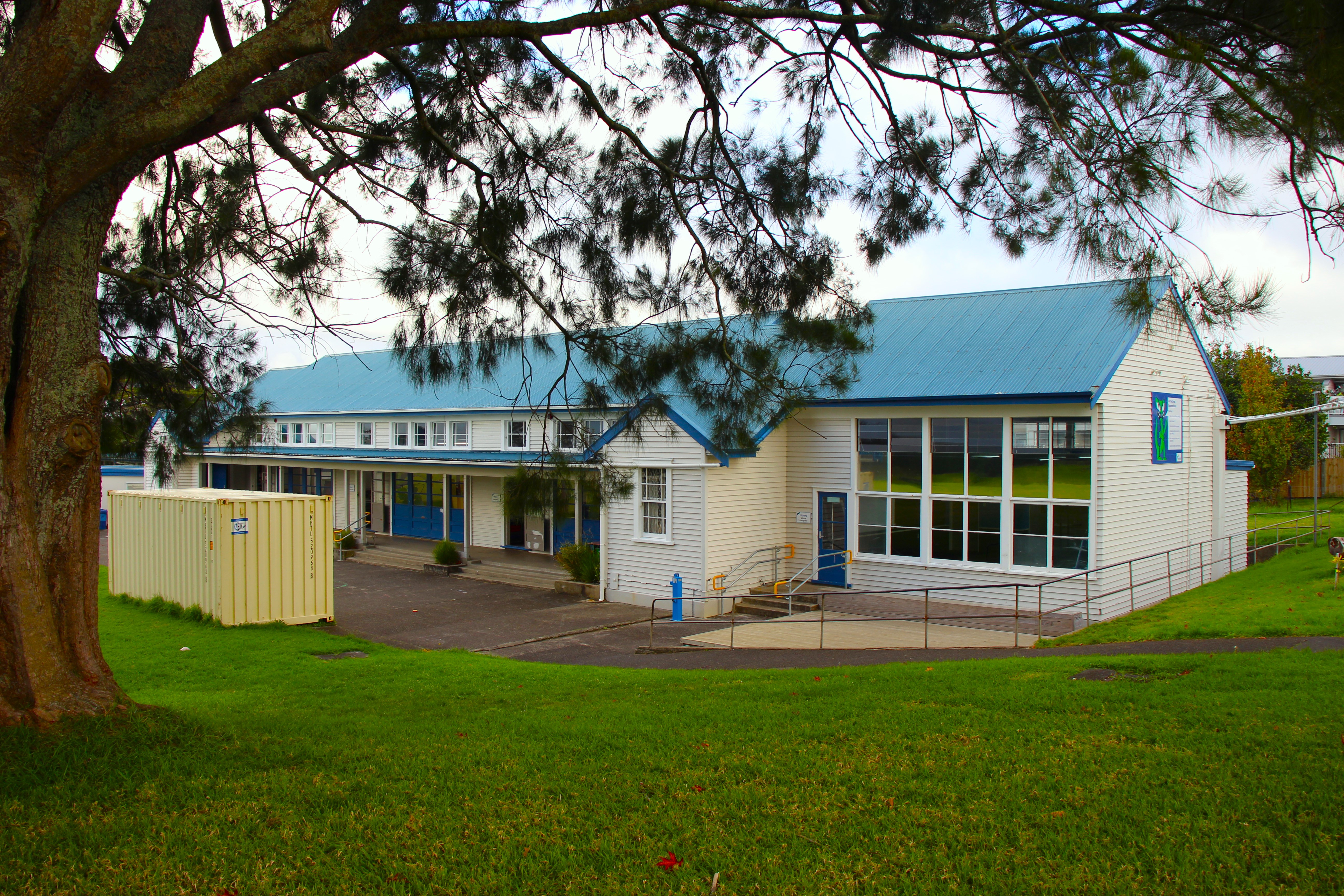 Exterior of a primary school classroom with grass and trees 