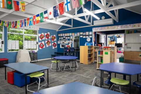 Photo of a classroom with desks, flags and chairs 