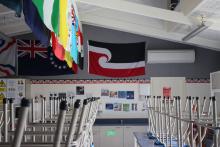 Classroom with chairs up for the holidays and flags displayed on wall 