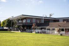Outdoor shot of a school with two storey classrooms and a grassy field 